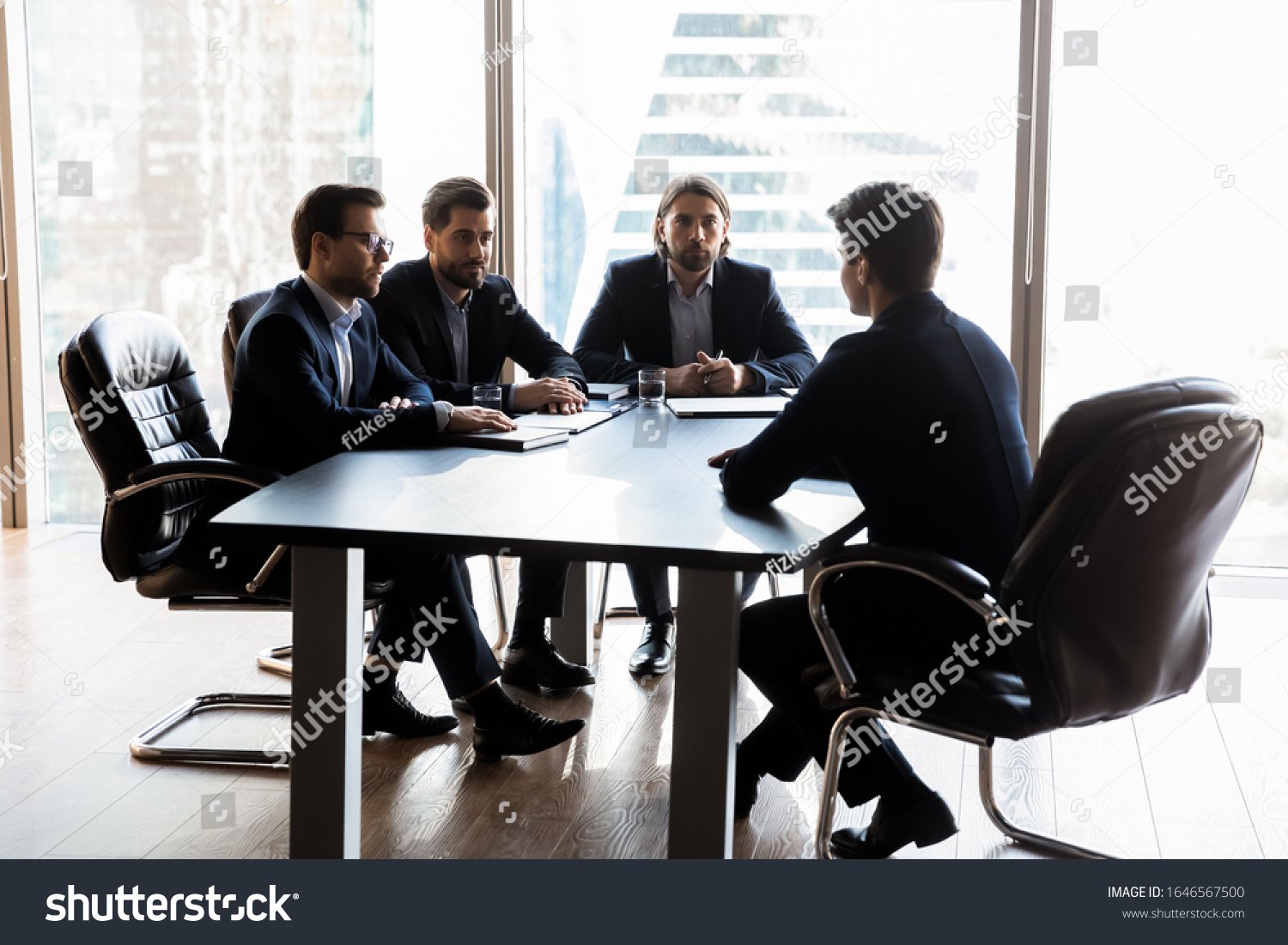stock photo applicant sitting in front three serious hr businessmen speaking during work interview in boardroom 1646567500 (1)